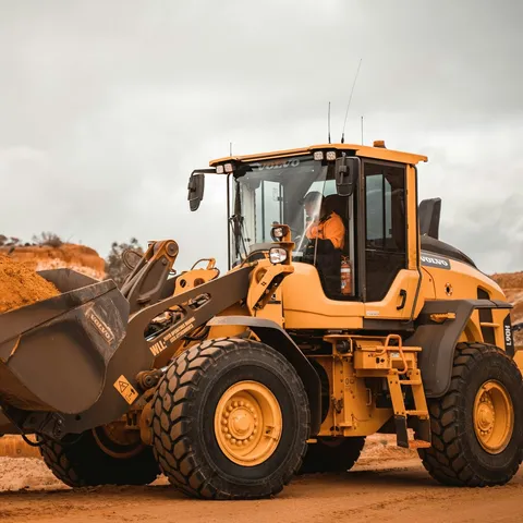A yellow wheel loader carrying soil on a work site